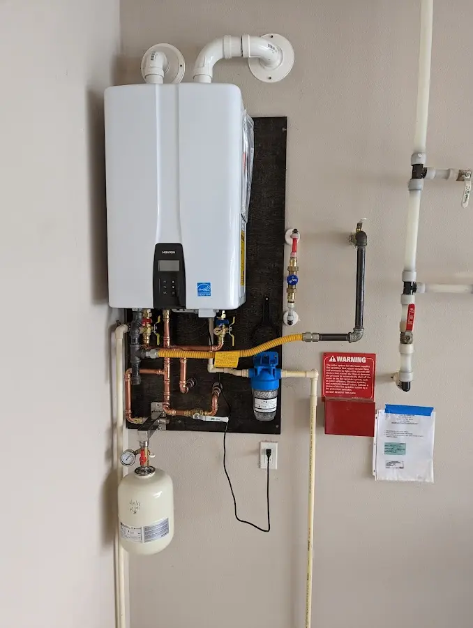 Professional plumber installing copper piping in a Henniker home